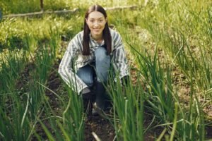 Gardener kneeling in field