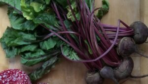 Bunch of purple beets with purple stems and green leaves